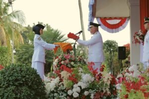 Gubernur Sumbar Mahyeldi Ansharulah sebaga inspektur Upacara Peringatan HUT ke-81 menyerahkan Bendera Merah Putih Kepada Anggota Paskibraka untuk Dikibarkan bertempat di Halaman kantor Gubernur Sumbar. Foto :  Makopim